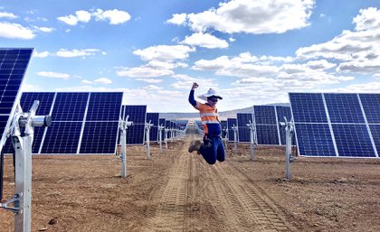 A worker jumps for joy at the Warwick Solar Farm project,